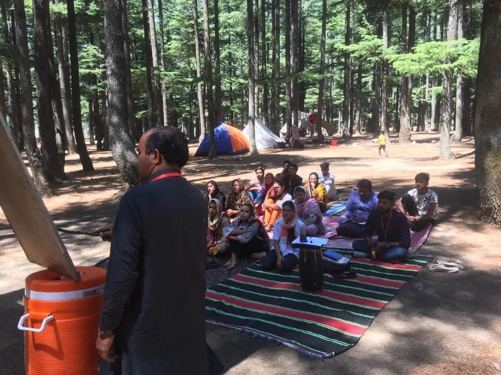 Presenter at a forest workshop with a board