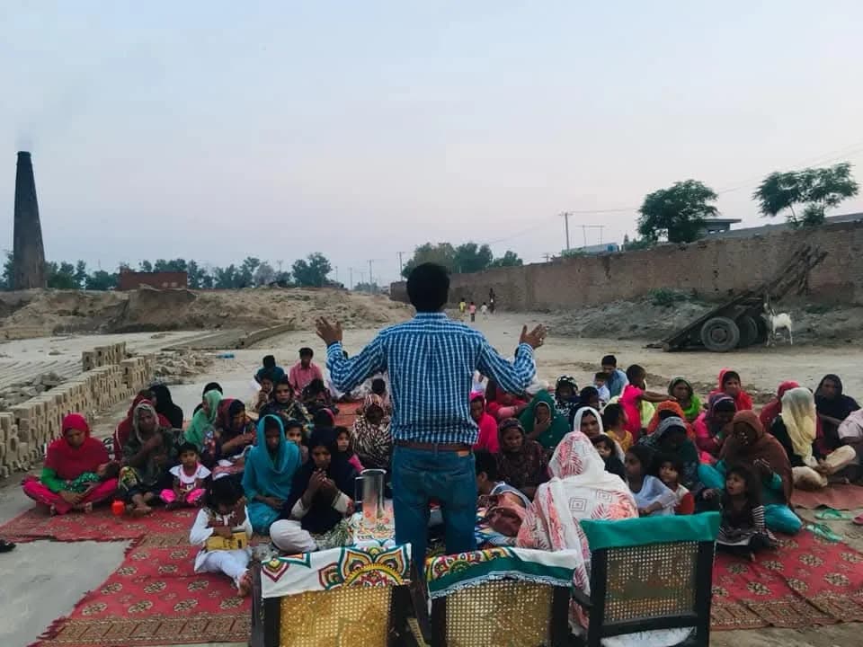 Community gathering at a brick-kiln outreach site
